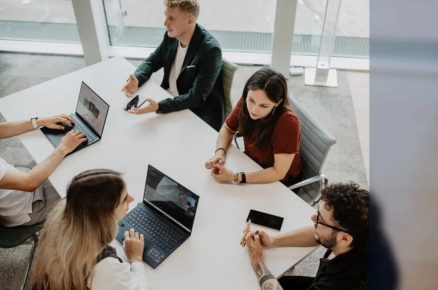 Epic-Fusion-Team arbeitet gemeinsam an Laptops am Besprechungstisch
